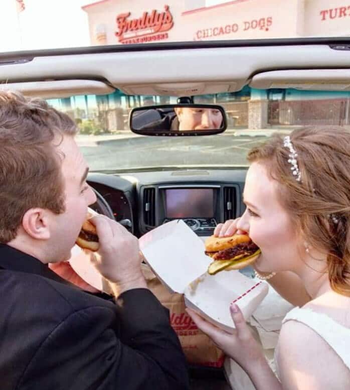 Recently married couple in convertible enjoying Freddy's burger